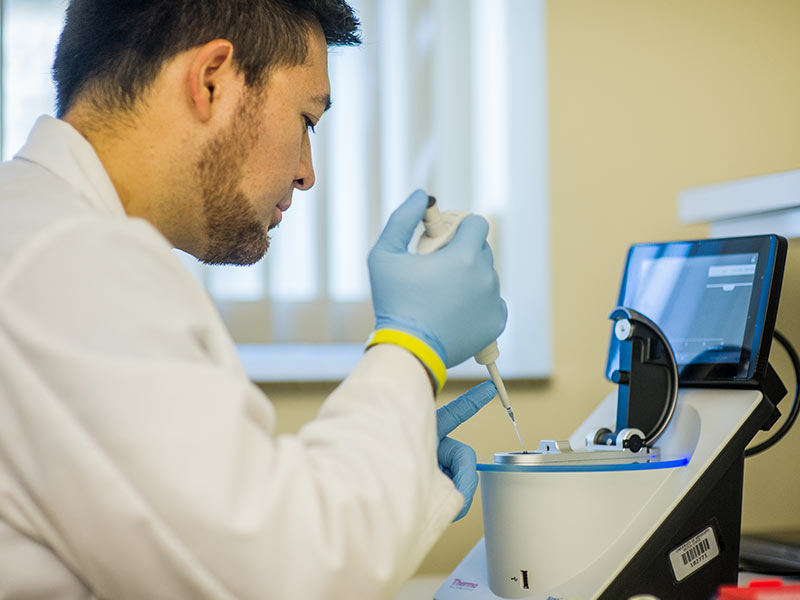 Jake Johnston, a researcher in the UMMC Molecular Genomics Core Facility, loads a genomic sample to measure its nucleic acid concentration.