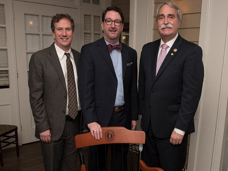 Hollingsworth, center, is presented a commemorative chair by Dr. Don Doty, School of Dentistry Alumni President elect and Dean David Felton.