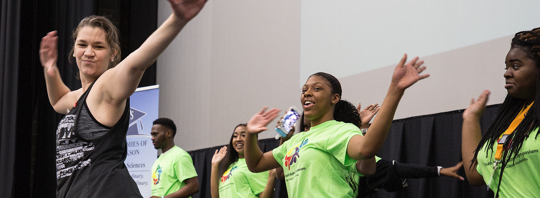 Josie Bidwell, a Zumba instructor and UMMC School of Nursing associate professor, leads teens at the Youth Health Matters Symposium in a dance session to open the Wednesday meeting.