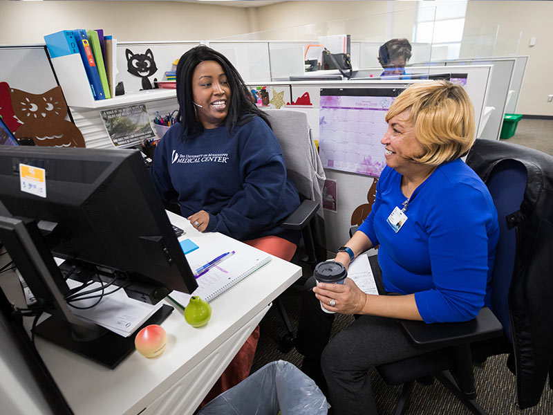 Tia Richardson, left, and Jonnie Miller, physician schedulers, confer at the new Jackson Medical Mall Access Center.