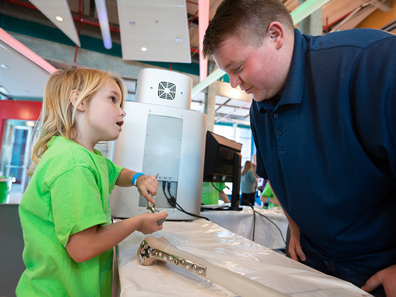 Biomedical materials science Ph.D. student Haden Johnson explains the ball-and-socket motion of an artificial hip joint to Finley Sumrall.