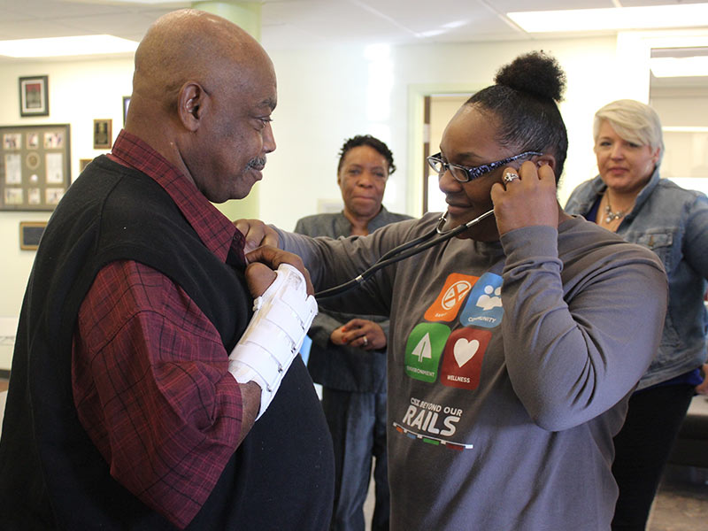 Abram Jones, left, holds still while Lywanda White listens to the heart of Thomas Griffin, White’s father.