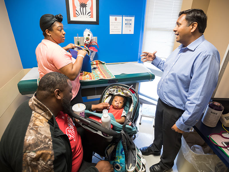 Jharad and Candace Faust talk with Aggarwal during a visit.