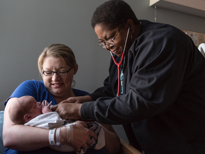 Nurse Virgle Smoot checks Renner Vowell's vital signs as he is cradled by mom Amanda Vowell of Ackerman.