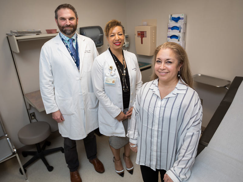 Maria Ricketts, right, poses with her surgical team, from left, Dr. Ben McIntyre and Dr. Shawn McKinney.