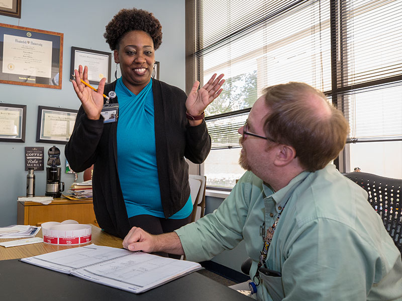 Dobbins explains a schedule change to her boss, Dr. Anderson Collier, director of the Division of Pediatric Hematology and Oncology.