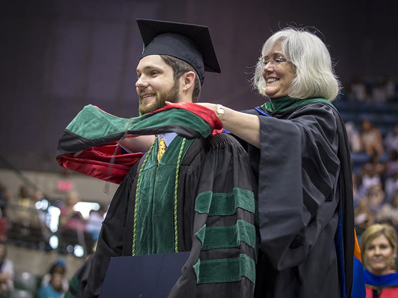 New School of Medicine graduate Stephen Wahl is hooded by his mother, Dr. Nancy Wahl, associate professor of pediatric emergency medicine.