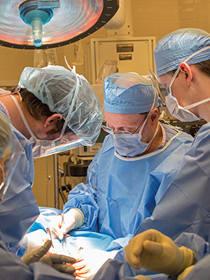 Harmon, center, performs a surgical procedure with the team including Dr. William Bruch, left, and medical student Ben Stevens.