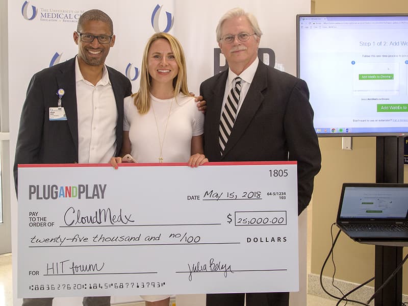 Displaying the check awarded to the pitch competition winner are, from left, Terrence Hibbert, director of innovation; Julia Belaya of event cosponsor Plug and Play; and Dr. Richard L. Summers, associate vice chancellor for research.