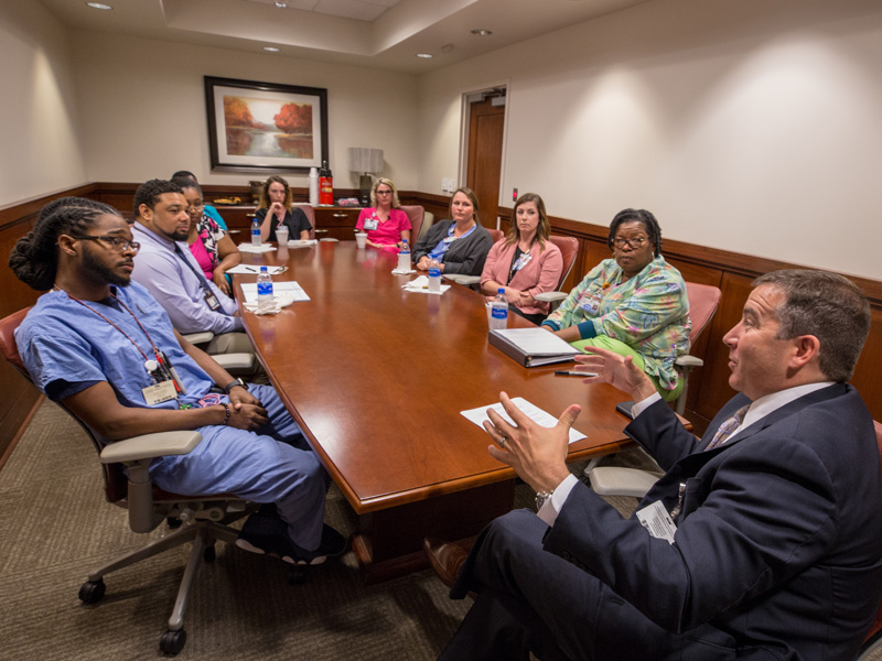Kevin Cook, right, CEO of the Health System, fields questions from selected employees during a monthly 