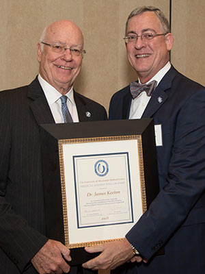Dr. James Keeton, left, the 2014 Distinguished Medical Alumnus awardee, is now a 2018 Hall of Fame inductee, as noted by the plaque he's accepting from Dr. Tim Folse, outgoing president of the Medical Alumni Chapter.