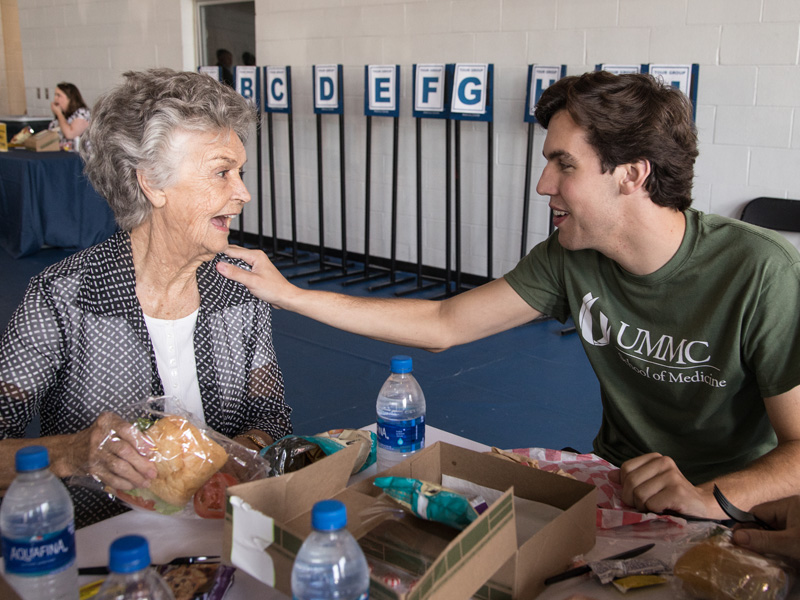 During Family Day lunch in the Student Union Gym, first-year medical student Alexander Knight shares a touching moment with his grandmother Helen Knight of Laurel.