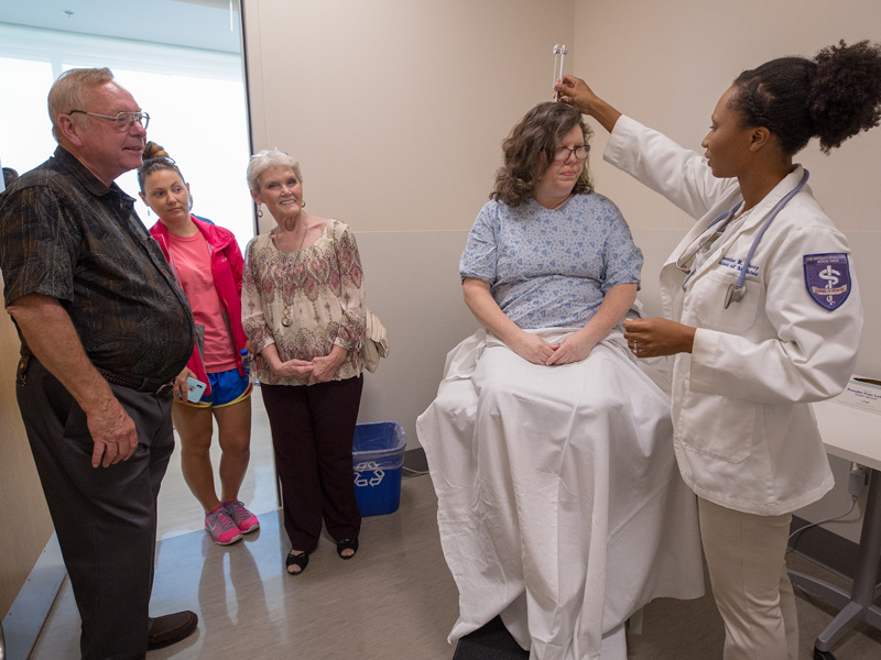 Family members of incoming students were taken to different locations throughout the school giving them a preview of what is to come for their first few years before seeing patients bedside. Here, family members, from left, Johnnie Whitaker, Shayna Smith and Jimmie Whitaker watch a demonstration by fourth-year medical student Jasmine Padgett, right, with mock patient Karen Walling at the Judith Gore Gearhart Clinical Skills Center.