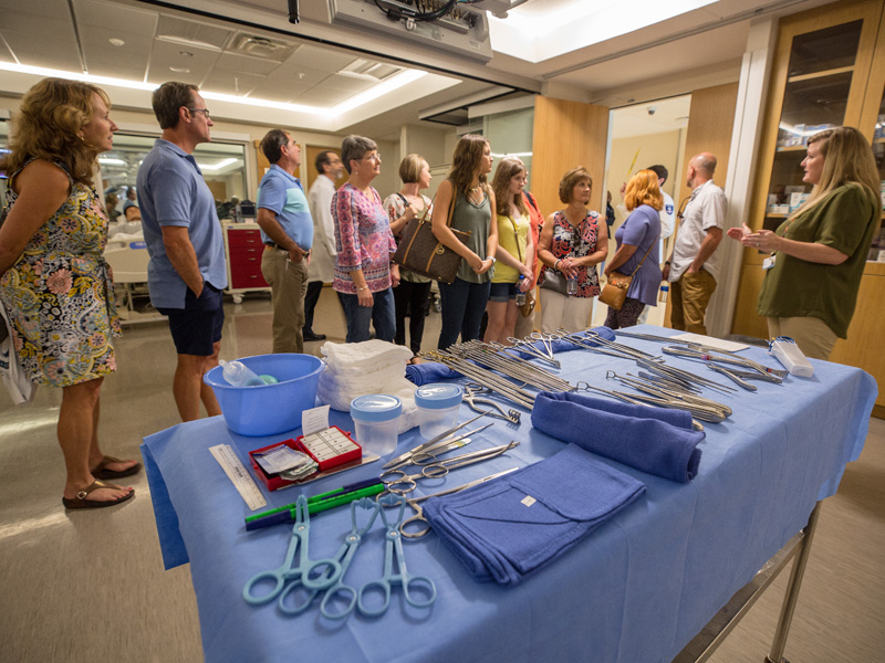Students, family and friends tour an operating room in the simulation suite.