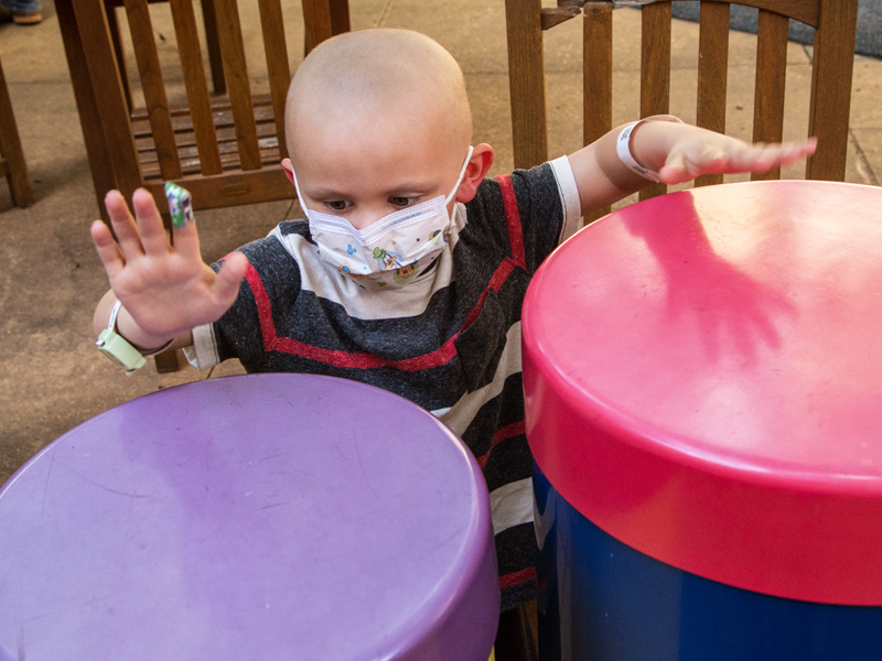 Batson Children's Hospital patient Harlan Harper of Sandy Hook plays the drums in the Rainbow Garden.