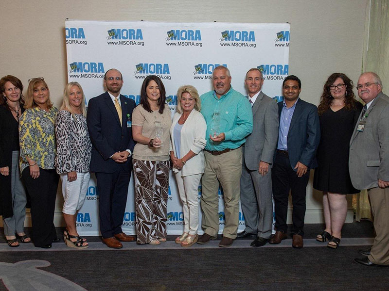 Members of the UMMC Grenada administration and transplant team are pictured with MORA chief business officer Russell Touchet, fourth from left. The team includes, from left, Julie Kilpatrick, Lori Thomas, Melissa Chamblee, Michelle Crawford, Cristy Seibel, Mark Turner, CEO Wes Sigler, Dr. Pradeep Vaitla, Amy Green and Dean Henderson.