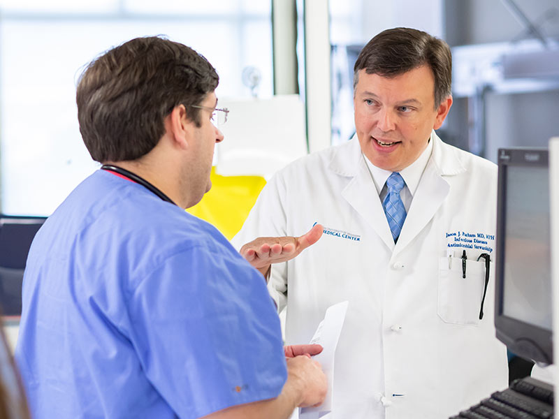 Parham, right, speaks with resident Dr. Benjamin Morehead.