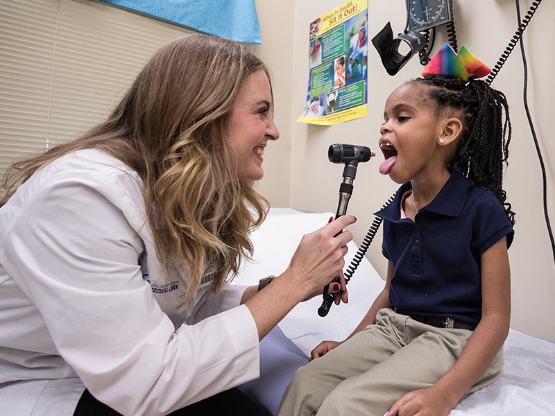 Lora Martin, family nurse practitioner in the School of Nursing, gives Raygen Pirtle, Galloway Elementary School student, a check-up in her school's health clinic.