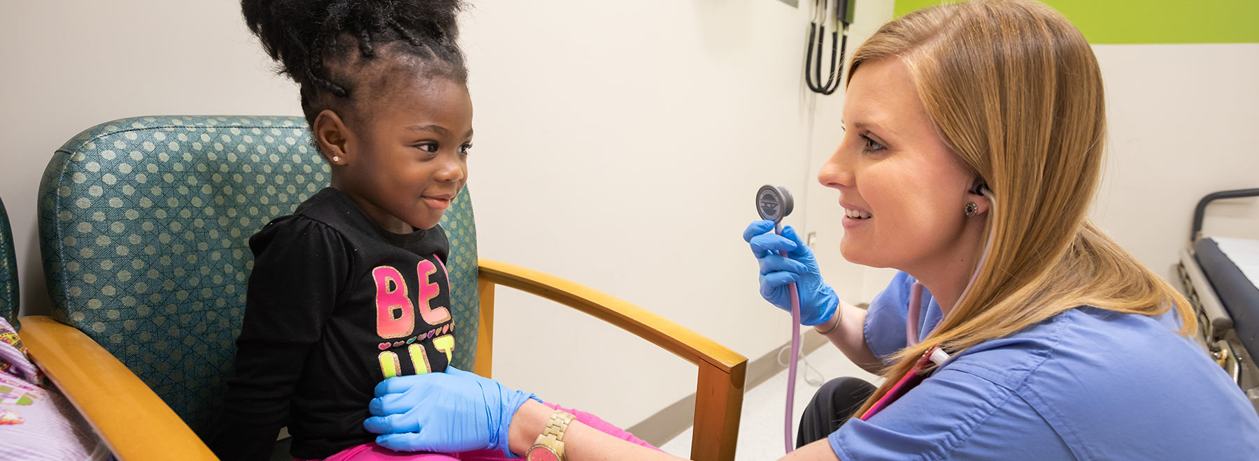 Patient Janiya Pate of Jackson smiles as nurse Leigh Moreau checks her stomach during a visit to the Pediatric Fast Track.