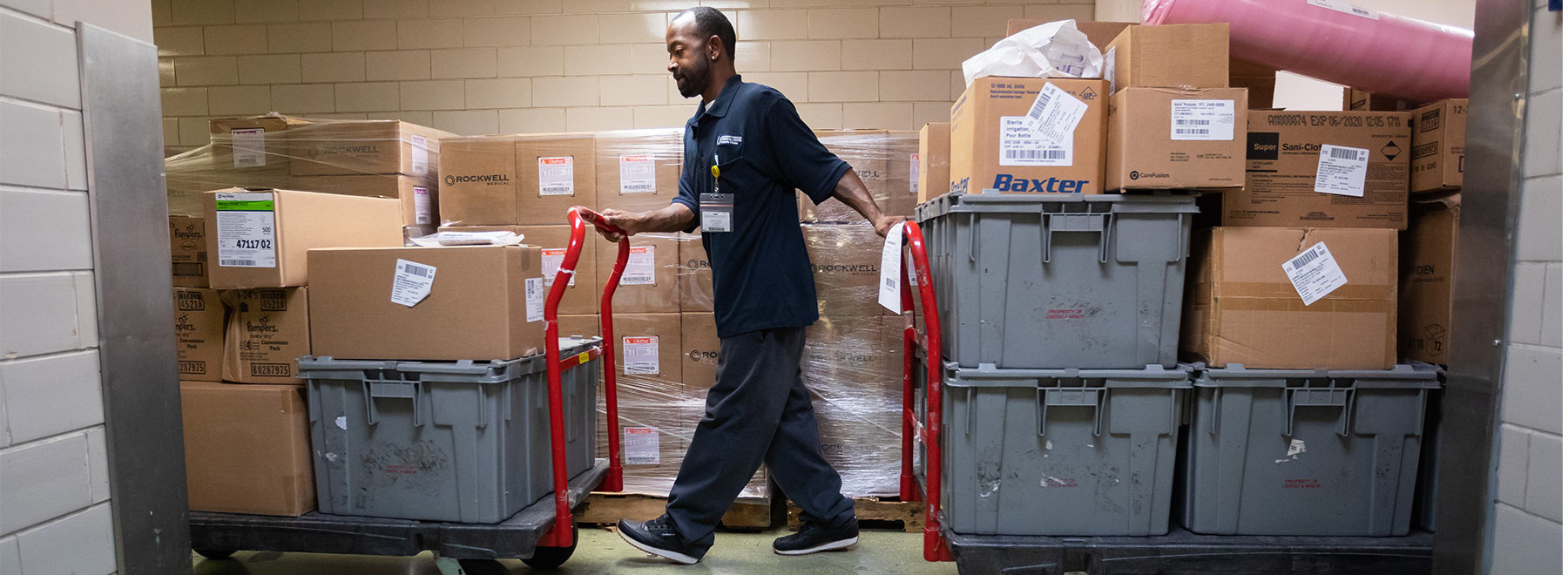 Materials Handler Terrell Howard guides two carts laden with supplies bound for the Children's Hospital.