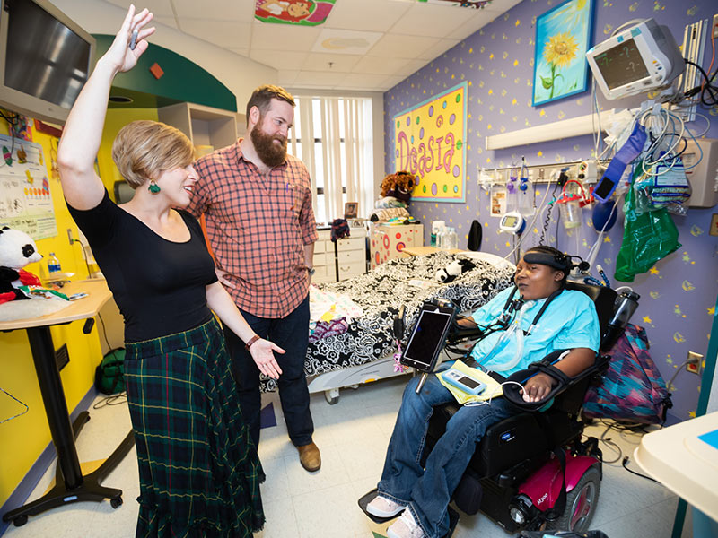 Erin and Ben Napier, getting a tour of Batson Children's Hospital before speaking at the Sanderson Farms Championship Women's Day luncheon, visit with patient DeAsia Scott.