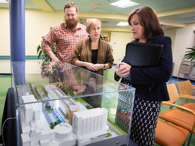 Dr. Mary Taylor shows Ben and Erin Napier, hosts of HGTV's "Hometown," an architectural model of UMMC's pediatric expansion.