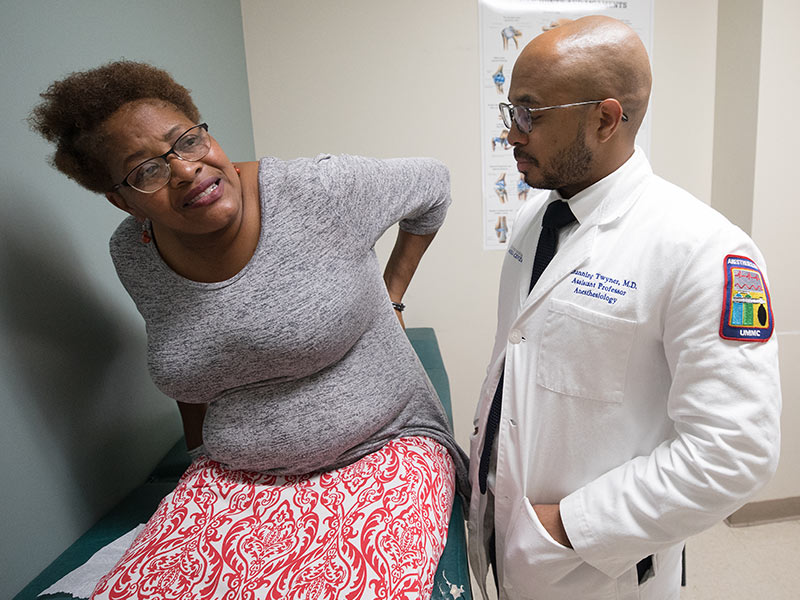 Dr. Channing Twyner examines the spinal cord stimulator worn by Betty Jean Bowman of Vicksburg, a pain management patient.