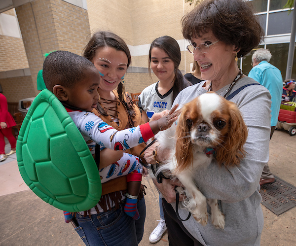 Batson Children's Hospital patient Jayceston Harris of Waynesboro pets therapy dog Ollie, held by owner Cynthia Jones of Brandon.