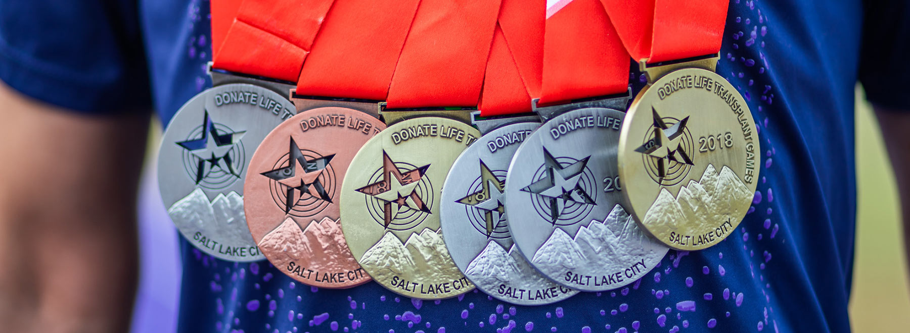 UMMC volunteer Timothy Lewis, a heart transplant recipient, shows off his Transplant Games of America medals at the Millsaps College track.