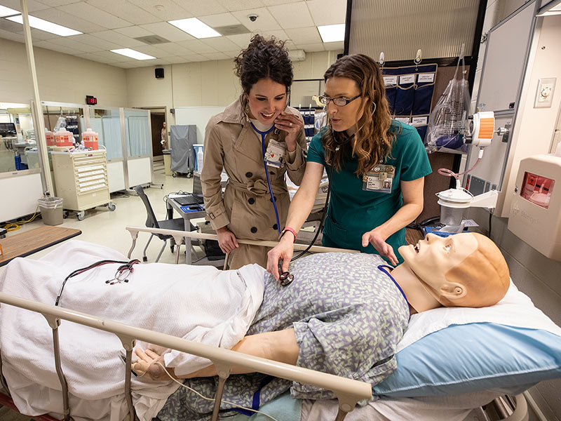 School of Nursing alumna Presly Lowry, left, RN, CICU, checks out the new and improved high fidelity simulator with instructor Melissa Klamm.