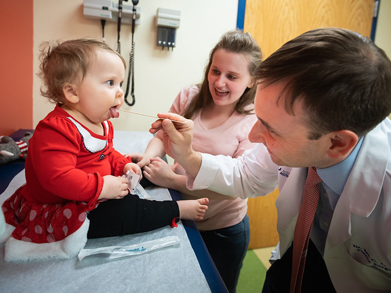 Dr. Ian Hoppe examines Anna Claire Carlisle after surgery while her mother, Ariel Davidson, looks on.