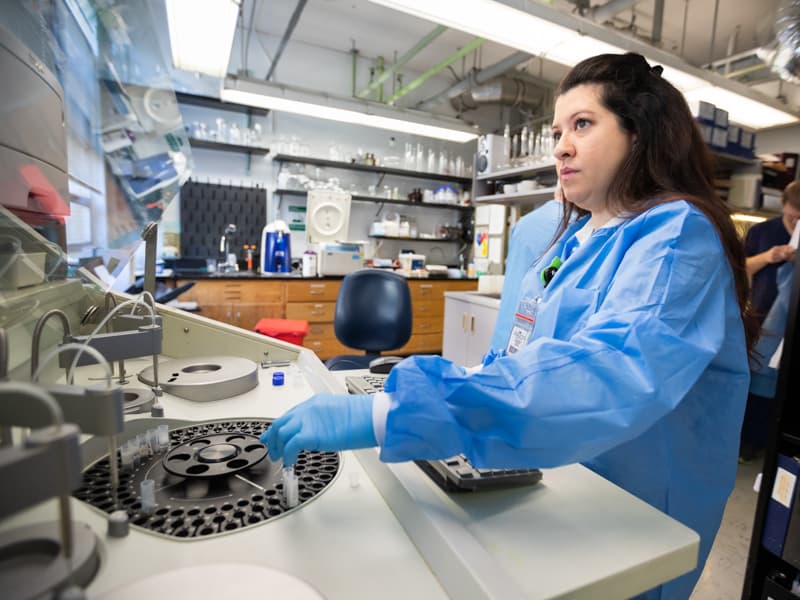 Alana Saldana, medical technologist, loads patient samples into a general chemistry analyzer for drug testing to detect compounds, including powerful opioids.