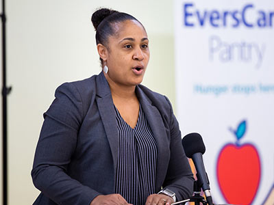 Felicia Lyles behind podium speaking at grand opening.