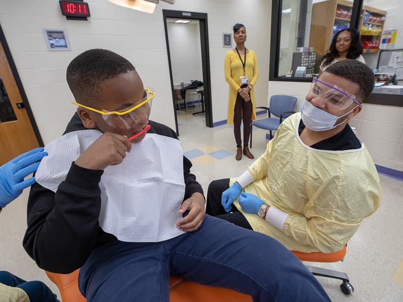 Johnson Elementary student Darnell Geralds shows fourth year dental student Devin Stewart his brushing technique.