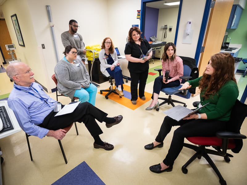 Discussing newborn health during rounds are, from left, Dr. Robert Annett, Mississippi State University student Reagan Brown, Christopher Clark, family nurse practitioner Marianna Riley, RN Beth Ammons, Dr. Courtney Walker and University of Southern Mississippi doctoral student Brandi Ellis.