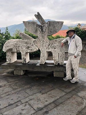 Brodell next to an animal sculpture in Italy
