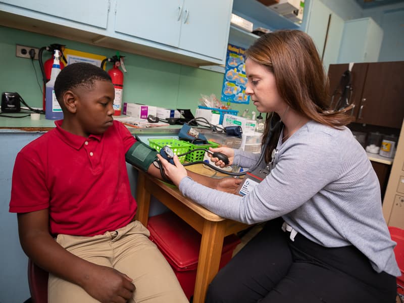 Amari Dunson, a student at South Delta Elementary School, gets his blood pressure checked by Sarah McGraw, family nurse practitioner, in the Mercy Delta Express clinic.