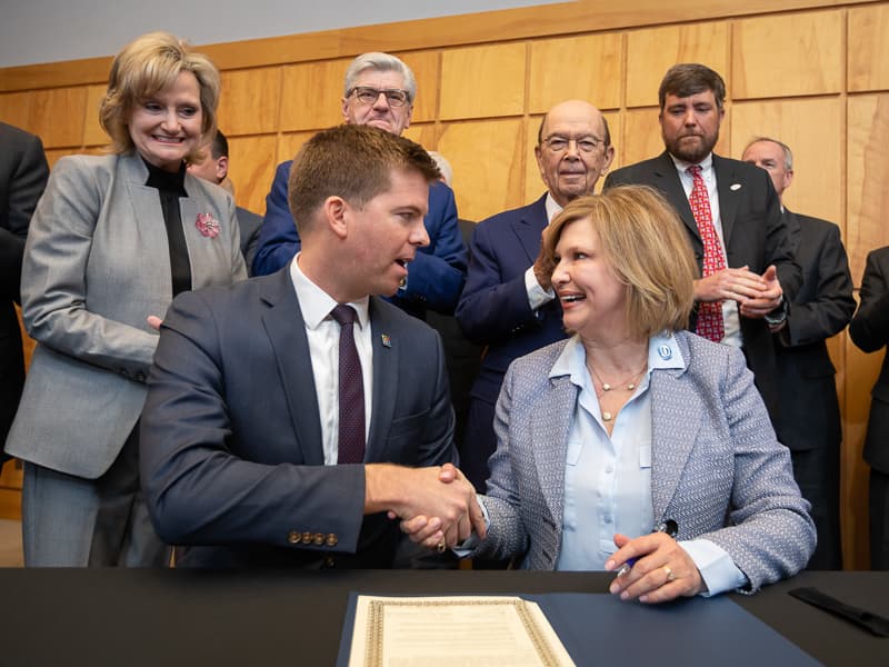 Dr. LouAnn Woodward, UMMC vice chancellor for health affairs and dean of the School of Medicine, shakes hands with Ed Parkinson, acting CEO of the FirstNet Authority, after each signed a memorandum of understanding between the two organizations aimed at improving emergency medical response communication and connectivity in Mississippi, especially in rural areas. Standing behind them are, from left, U.S. Sen. Cindy Hyde-Smith, Gov. Phil Bryant, U.S. Secretary of Commerce Wilbur Ross and Medical Director of the UMMC Mississippi Center of Emergency Services Dr. Damon Darsey.