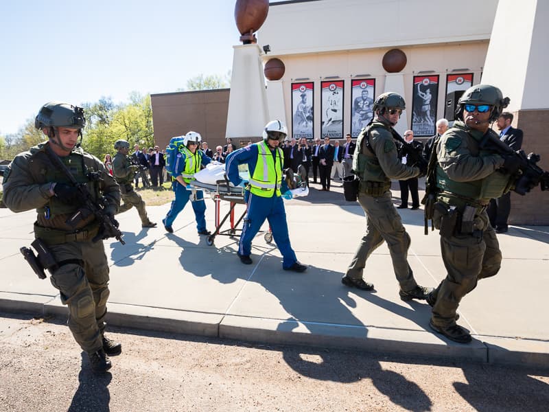 As part of a hostage scenario demonstration, members of the Mississippi Highway Patrol stand guard as AirCare paramedics roll a dummy shooting victim to a waiting helicopter at the Mississippi Agriculture and Forestry Museum.