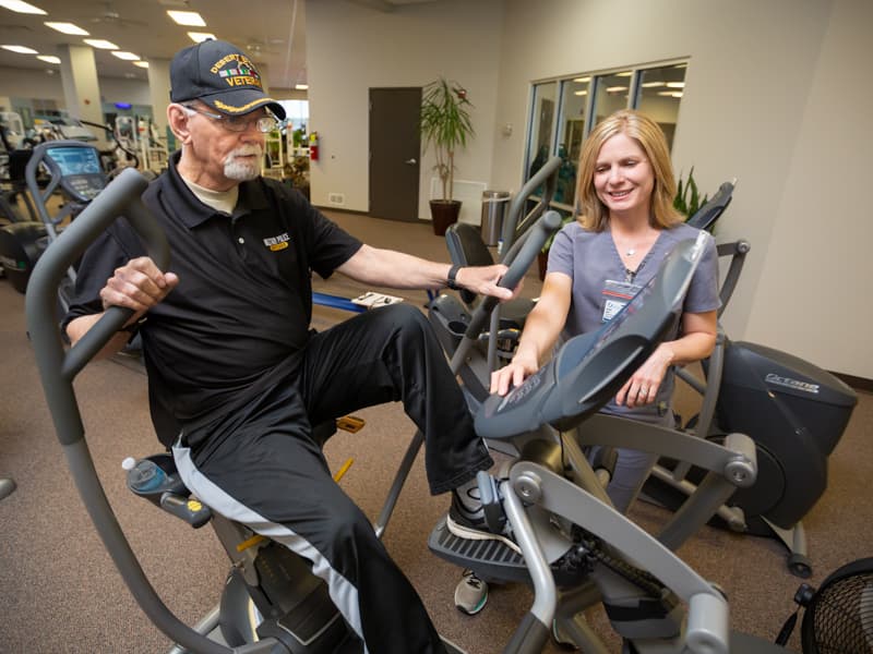 Richard Norton of Florence exercises on a seated elliptical with guidance from physical therapist Rachel Dear.