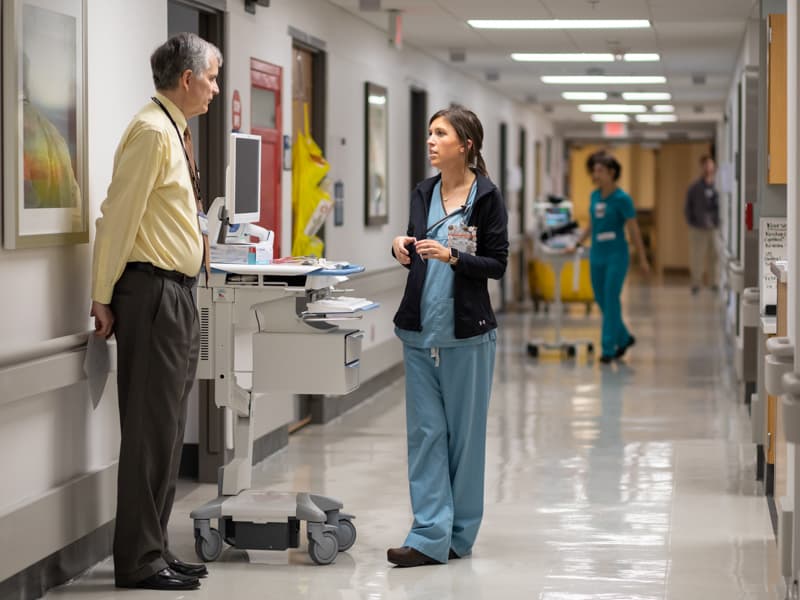 Nurse Manager Brittany Ransom, center, speaks with Food and Nutrition Services Contractor Jim McKeown on 2 West.