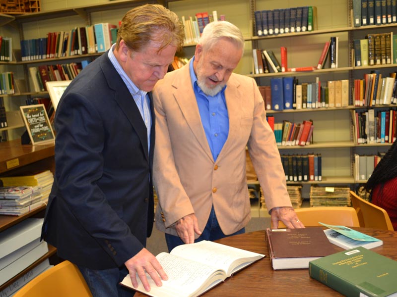 During a recent visit to the Medical Center, Wayne Lee, left, and James Lee examine historical documents related to the asylum that had housed their grandfather, John Benedict Whitfill.