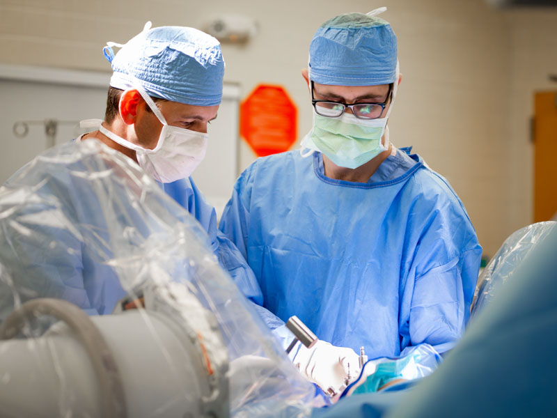 Dr. Jim Hurt, left, performs an operation with the assistance of Dr. Reaves Crabtree. an orthopaedic surgery resident.