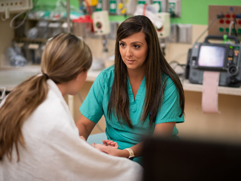 In this photo illustration, Samantha Phelps, a registered nurse in the Pediatric Emergency Department, gently questions a young patient suspected of being a human trafficking victim.