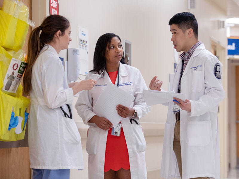 Dr. Malorie Holmes, center, conducts rounds with Dr. Alisha Parker, left, a nephrology fellow, and Dr. Wisit Cheungpasitporn, right, assistant professor of medicine, nephrology.