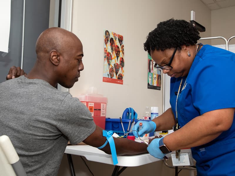 Sharron Vaughn, UMMC Biobank recruiter, draws blood from Travis Key of Jackson for the All of Us research study.