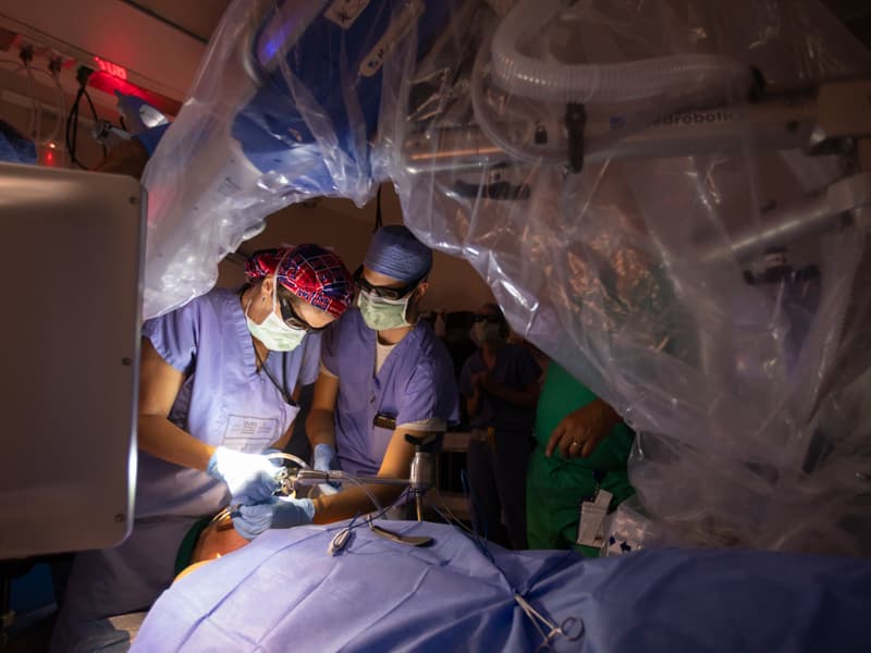 Using a flexible robotic instrument with an attached scope, Dr. Lana Jackson, left, removes cancers of the throat that are difficult to access. She is assisted by fifth-year resident Dr. Steven Curti.