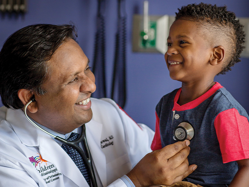 Dr. Avichal Aggarwal listens to Kingston Murriel's heartbeat.