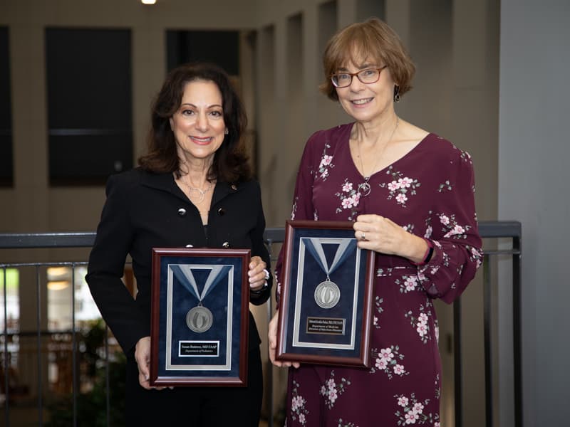 Dr. Susan Buttross, left, and Dr. Deborah Konkle-Parker received platinum medallions during the Excellence in Research Awards ceremony.