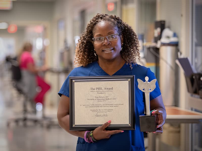 PHIL honoree Trina Dobson displays her award certificate and Appreciation sculpture.